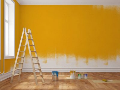 Wand in einer Wohnung mit gelber Farbe streichen bei der Renovierung